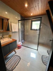 a bathroom with a shower and a sink at URUBICI - Cabana da Montanha in Mundo Novo