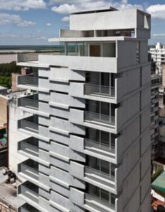 un edificio alto con balcones a un lado. en Altos de Maipu en Rosario