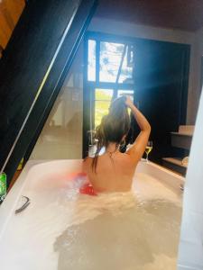 a woman is sitting in a bath tub at URUBICI - Cabana da Montanha in Mundo Novo