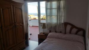 a bedroom with a bed and a window with a view at Habitaciones Cómodas con baño individual in Santa Cruz de Tenerife