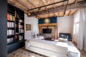 a living room with a large white couch and a fireplace at B&B Sterckxhof in Meise