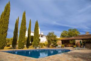 a swimming pool in front of a house with trees at Assumar Country House in Assumar