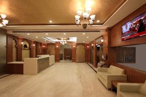 vestíbulo con TV y sala de espera en Ambaari hotel, en Mysore