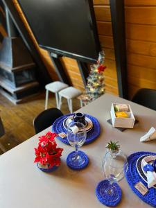 a table with blue plates and glasses and a christmas tree at URUBICI - Cabana da Montanha in Mundo Novo