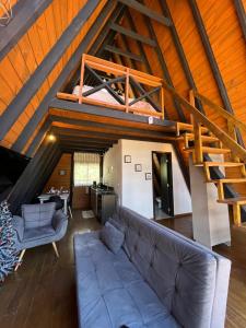 a living room with a couch and a staircase at URUBICI - Cabana da Montanha in Mundo Novo
