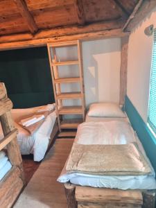 two bunk beds in a room with wooden ceilings at Mala koliba Dolina mira in Pale