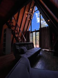 a living room with a couch in a attic at URUBICI - Cabana da Montanha in Mundo Novo