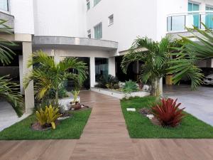 um pátio de um edifício com palmeiras em COBERTURA EM CABO FRIO / RJ em Cabo Frio