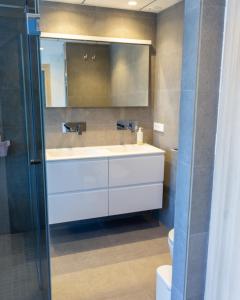 een badkamer met een wastafel en een spiegel bij Apartamento Ático Estrasburgo suites in Jávea