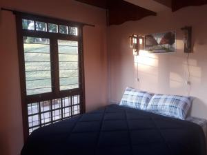 um quarto com uma cama e uma janela em PARADOURO BOCA DA SERRA em São Francisco de Paula