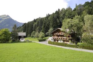 a house in the middle of a green field at Utas Ferienhof in Sankt Gallenkirch