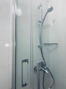La salle de bains est pourvue d'une douche avec une porte en verre. dans l'établissement Confortable-House, à Vitry-sur-Seine