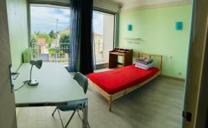 - une chambre avec un lit, un bureau et une fenêtre dans l'établissement Confortable-House, à Vitry-sur-Seine
