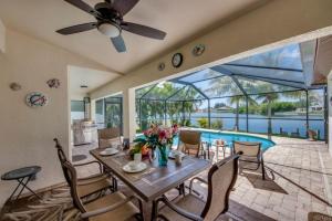 - une salle à manger avec une table, des chaises et une piscine dans l'établissement Villa Florida Vacation, à Cape Coral