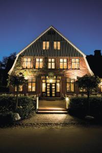 a large brick building with windows and doors at night at Hotel Ole Liese in Panker