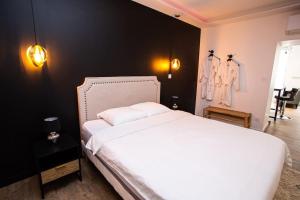 1 dormitorio con cama blanca y pared negra en BD ROOM LOVE ROOM COSY à SAINT-ETIENNE, en Saint-Étienne