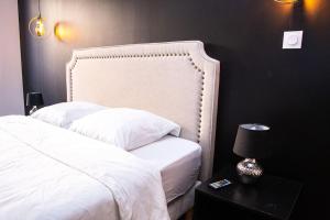 a bedroom with a white bed and a black wall at BD ROOM LOVE ROOM COSY à SAINT-ETIENNE in Saint-Étienne