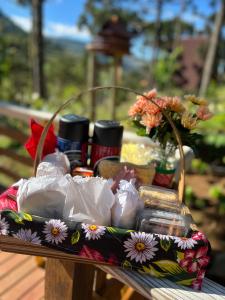 a picnic basket with flowers on a table at URUBICI - Cabana da Montanha in Mundo Novo +37 photos