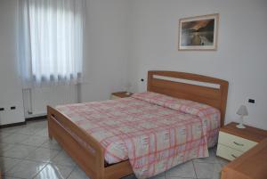 a bedroom with a bed with a red and white comforter at Appartamenti Stanga Ivo in Tenno