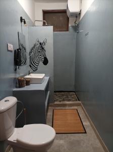 a bathroom with a zebra painting on the wall at Zanzicrown in Nungwi