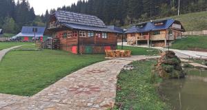 a log cabin with a stone path next to a building at Mala koliba Dolina mira in Pale +3 photos