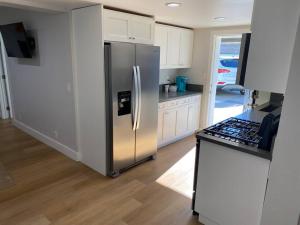 a kitchen with a stainless steel refrigerator and a counter at Steps To The Beach, Main Street and Pacific City - 2BR in Huntington Beach