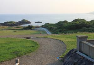 a path leading down to the ocean on a hill at Puffin Lodge Accomodation in Killybegs