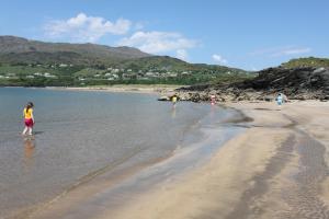 un grupo de personas de pie en el agua en una playa en Puffin Lodge Accomodation en Killybegs