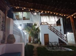 a white building with a staircase and tables and chairs at Zanzicrown in Nungwi