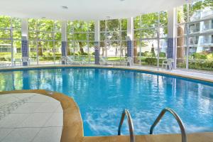 a large swimming pool with a chair in a building at Hotel Ralitsa Aquaclub - All Inclusive plus Aquapark in Albena