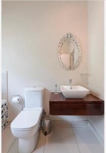 a bathroom with a white toilet and a sink at Modern Apartment in Rosebank in Johannesburg