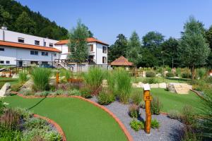 un jardín con césped verde y una casa en el fondo en Hotel a restaurace U Vychopňů, en Vsetín