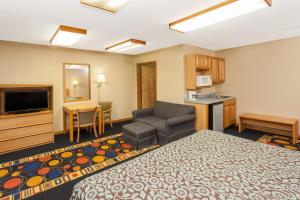a hotel room with a bed and a kitchen at Days Inn by Wyndham Farmer City in Farmer City
