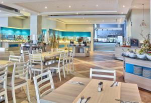een restaurant met tafels en stoelen en een keuken bij Hotel Ralitsa Aquaclub - Ultra All Inclusive plus Aquapark in Albena