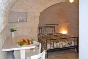 um quarto com uma cama e uma mesa com uma tigela de fruta em Trullo De Amicis n°5 em Alberobello