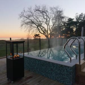 a hot tub with a fireplace next to a sunset at Smygehus Havsbad in Smygehamn