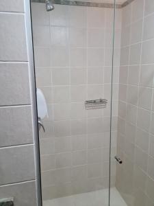 a shower with a glass door in a bathroom at Flat maravilhoso no Centro de Taguatinga - Pistão Sul in Taguatinga