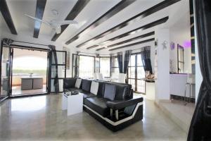 sala de estar con sofá negro y mesa en HL 015 Holiday rentals 4 Bedrooms 4 Bathroom villa with private pool, en Fuente Alamo