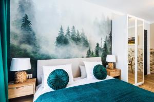 ein Schlafzimmer mit einem Bett und einem Gemälde an der Wand in der Unterkunft Przystanek Babia Apartamenty in Lipnica Wielka