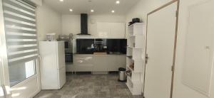 a kitchen with white cabinets and a counter top at Joli appartement rénové avec terrasse in Brides-les-Bains