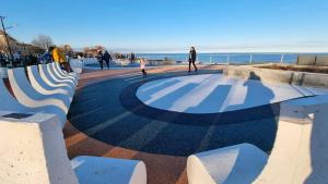 a group of benches sitting next to the beach at Iris&carina in Eforie Sud +8 photos