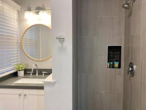 un bagno con doccia, lavandino e specchio di Steps To The Beach, Main Street and Pacific City - OCEAN VIEWS a Huntington Beach