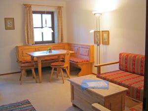 ein Wohnzimmer mit einem Tisch und einem Sofa in der Unterkunft Gschwendtnerhof App17 Blum in Aschau im Chiemgau