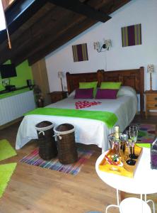 a bedroom with a bed with green and purple pillows at La Fuente in Umbrías