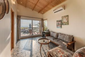 a living room with a couch and a table at Morii by the sea - Morjim Beach in Morjim