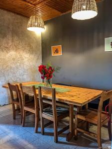 una mesa de comedor de madera y sillas con flores. en Hidden Valley Backpackers, en Iringa 25 fotos más