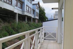 a white fence next to a building with a billboard at Main Street with a great Balcony in Ushuaia +4 photos
