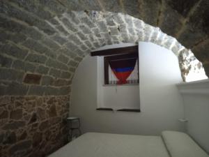 Cette chambre dispose d'une fenêtre dans un mur de briques. dans l'établissement Antica Fonni, à Fonni