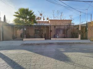 un edificio con una valla y una palmera en Casa en La zona Centro de la Ciudad, en Ciudad Juárez