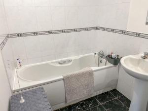 a bathroom with a white tub and a sink at 4c Gaia Lane in Lichfield